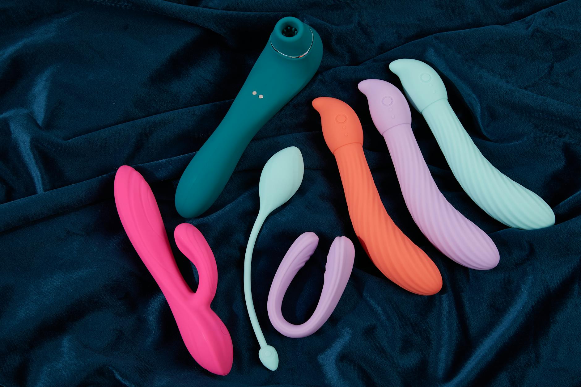 Colorful arrangement of clitoral suction toys on a bright yellow background