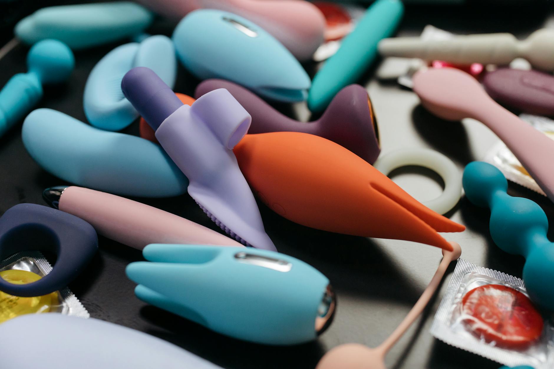 An array of vibrant adult toys including vibrators and clitoral stimulators in close-up view