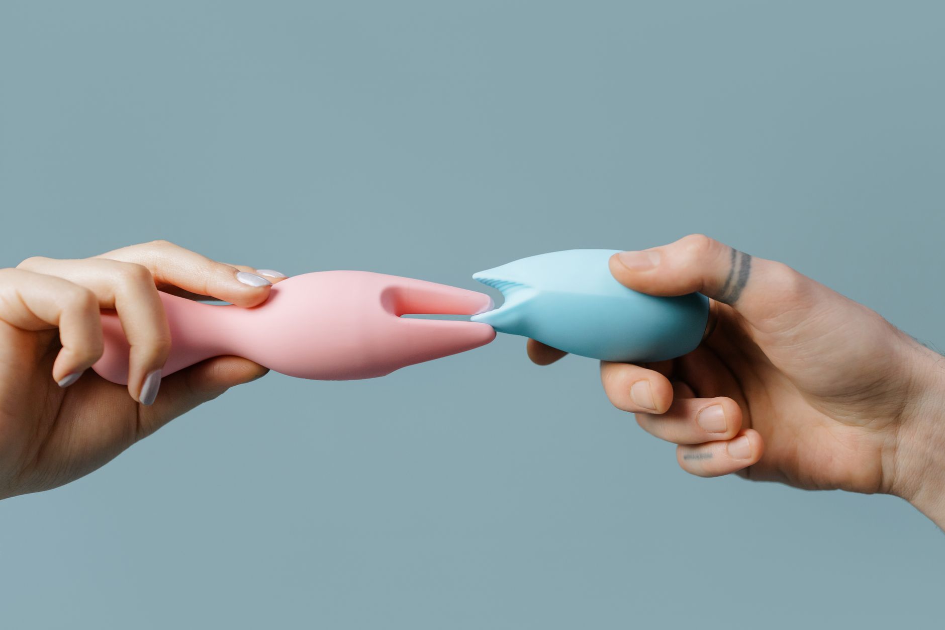 Hand holding a vibrator against a minimalist backdrop, symbolizing intimate self-care and personal pleasure